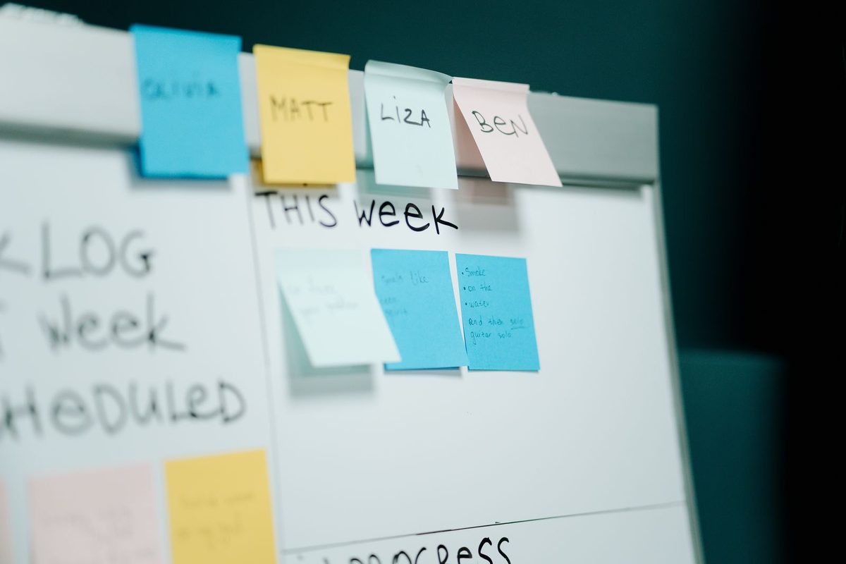 A whiteboard covered in colour-coded sticky notes used to plan content