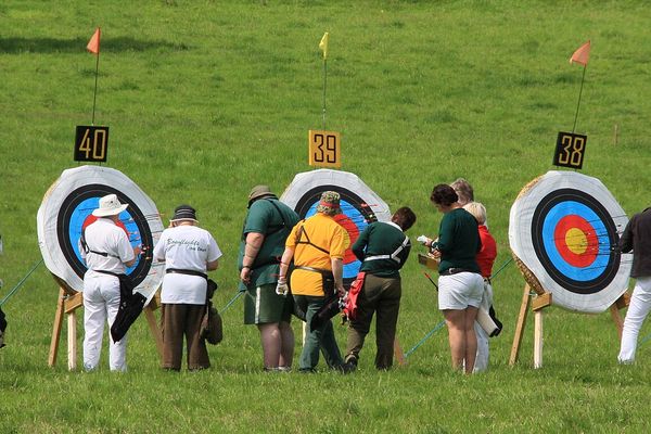 Archers collecting arrows and scoring the target at an archery competition
