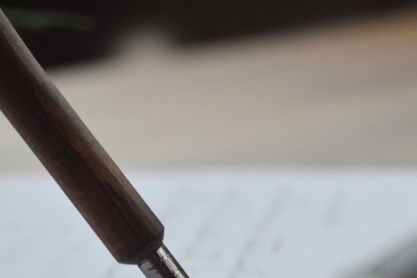 A fountain pen writing cursive script on paper
